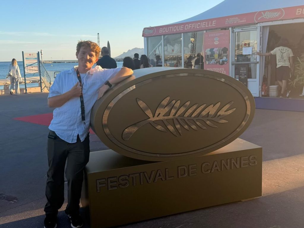 Student Cory Ray by the “Festival De Cannes” sign. Photo Credits: Cory Ray
